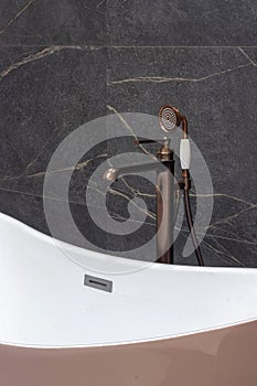 Part of the bathroom with a view of the hand shower, faucet, bathtub.