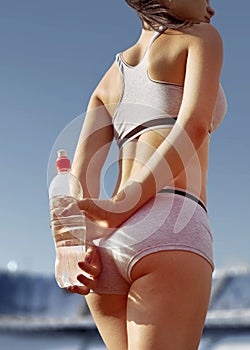 Part of beautiful athletic woman with bottle