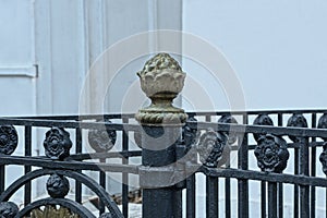 Part of a black metal fence with iron bars