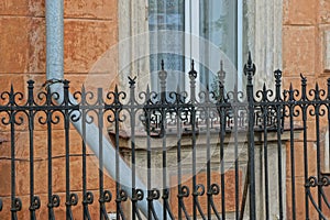 Part of a black metal fence made of sharp iron rods