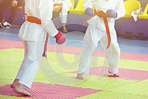 Part of the body of a karate man in kimono in gloves in the gym