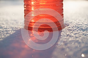 Part of bottle with non-freezing windshield washer fluid, snow background