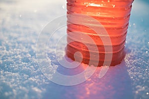 Part of bottle with non-freezing windshield washer fluid, snow background