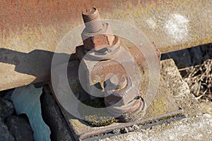 Part of brown steel rails and rusty bolts and nuts on the railroad