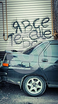 Part of the car on the background of the wall with the inscription in Russia