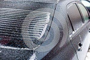 part of a car covered with ice at shallow depth of field