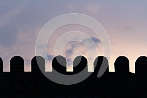 Part of castle wall silhouette on sunset with cloudy sky background. Tbilisi, Georgia.