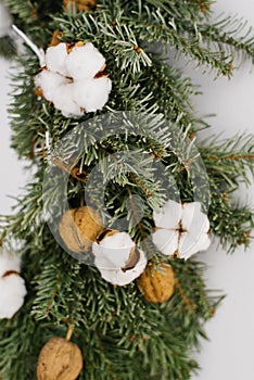Christmas wreath close-up: spruce, cotton and walnuts