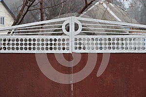 Part of closed red white metal gate