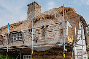 Part completed thatched roof renovation seen on an old english cottage.