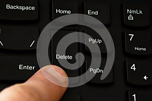 Part of a computer keyboard. Press a finger on the key