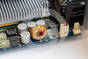 Part of a computer motherboard with capacitors, a transformer and a cooling radiator