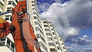 Part of a construction machine excavator or crane with multi-storey building under construction new residential complex on the