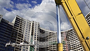 Part of a construction machine excavator or crane with multi-storey building under construction new residential complex on the