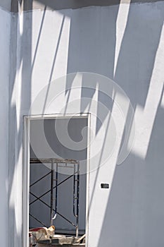 Part of construction worker with rubber glove using long triangle trowel to spread and plastering cement on the floor in