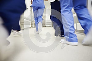 Part of doctors running through corridor in hospital