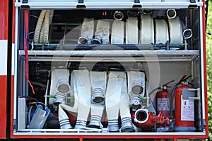 Part of equipment of a firetruck: water pump engine, control panel, manometers, hoses