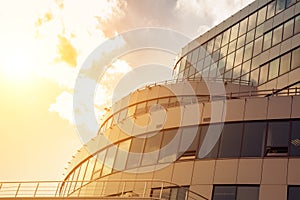 Part of the facade of a modern building is finished with slabs and glass in the rays of the setting sun as a background or a backd