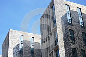 Element of the facade of a high-rise residential brick building with panoramic windows. Modern architecture