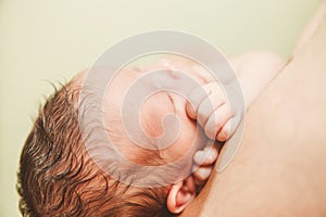 The Part of Face of Newborn Baby with Small Touching Hands.