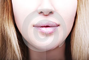 Part of face, young woman close up. plump lips after filler injection.