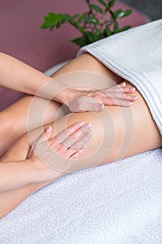 Part of the female leg getting massage by beautician in the beauty salon, close up
