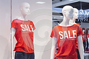 Part of a female mannequin dressed in casual clothes with the text sale in a shopping department store for shopping, fashion