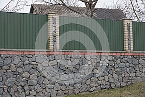 Part of a fence wall on the street made of green metal