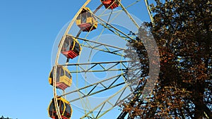 Part of the ferris wheel against the background of foliage and heaven