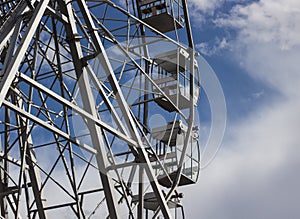 Part of a ferris wheel against a blue sky