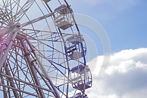 Part of a ferris wheel against a blue sky