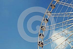 Part of Ferris wheel against blue sky