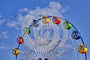 Part of a ferris wheel with round cabins decorated with ornaments