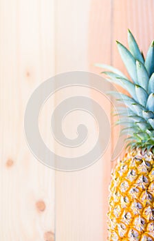 Part of fresh pineapple on natural wooden pallet background, `tropical summer` concept