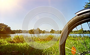 Part of the front wheel of a bicycle on a meadow in front of a lake in summer in Germany