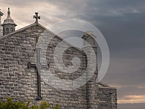 Part of Galway Cathedral, Wall and rood with crosses, Calm and peaceful sunset sky