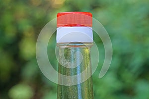 Part of glass bottle with soy sauce with closed white red plastic cap