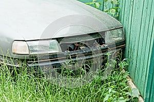 Part of a gray old passenger car with a hood and headlights