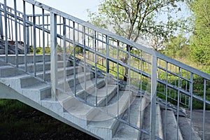 Part of a gray pedestrian bridge made of concrete steps