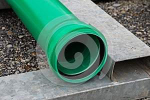 Part of green plastic pipe with a connecting flange at the end.