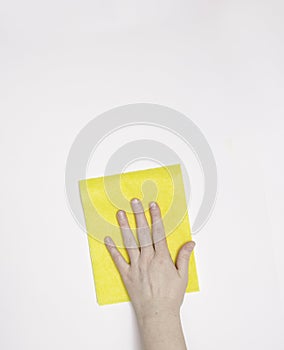 Part of the hand with a yellow cloth for dusting and removing dirt. Cleaning, white background, free space for text.