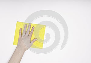 Part of the hand with a yellow cloth for dusting and removing dirt. Cleaning, white background, free space for text.