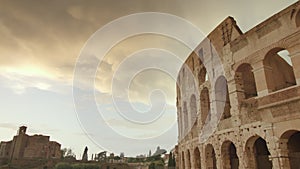 Part of historical Colosseum in Rome at cloudy sunset