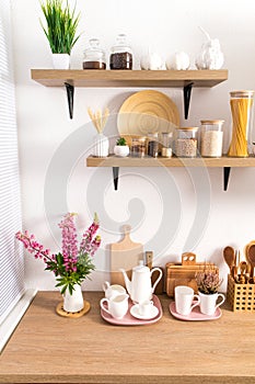 Part of the interior of the modern kitchen . open shelves with various jars and countertop with kitchen utensils. ecologically