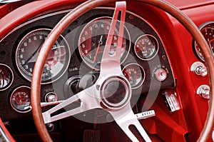 Part of interior with steering wheel, speedometer, revs, fuel, oil, water temperature and battery dials and knobs on the front