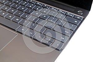 Part of laptop keyboard and touchpad of opened laptop on white side view