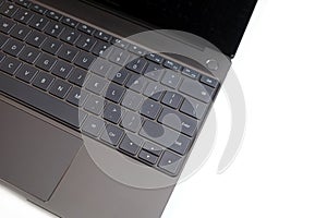 Part of laptop keyboard and touchpad of opened laptop on white top view