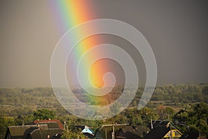 Part of a large rainbow over the private sector, close-up, a rainbow over a residential area of the city
