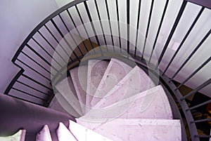 Part  of marm staircase spiralling down. Rounded stone staircase