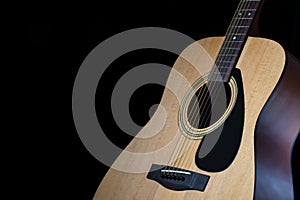 Part of modern acoustic guitar on black background